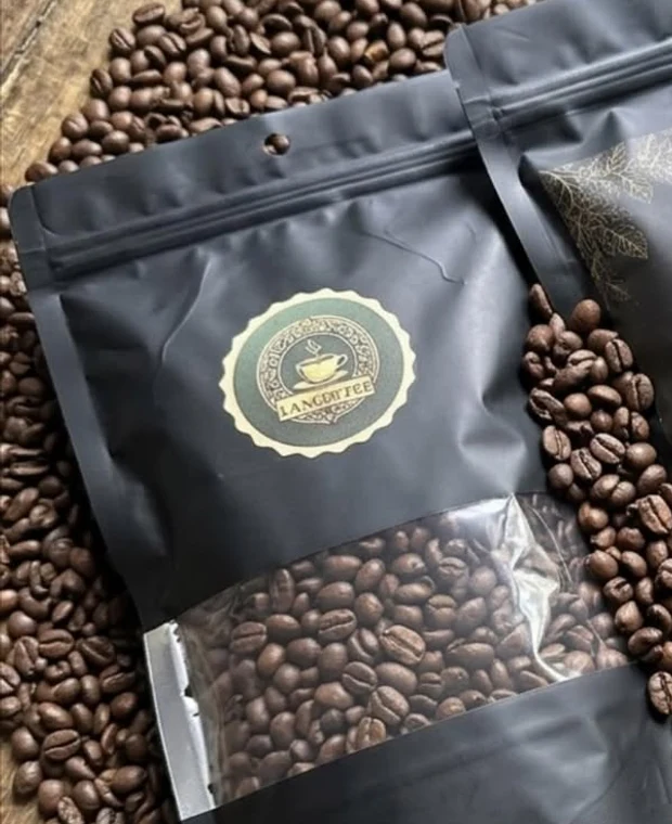Pacote de café LanCoffee em grãos, com janela transparente mostrando os grãos torrados